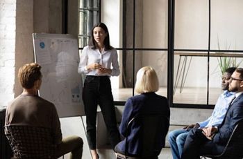 A woman presenting to her colleagues